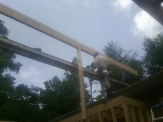 Carpenter setting a ridge beam over a new addition frame — Ice Dam Removal by Roofing Brothers in Roslyn Heights