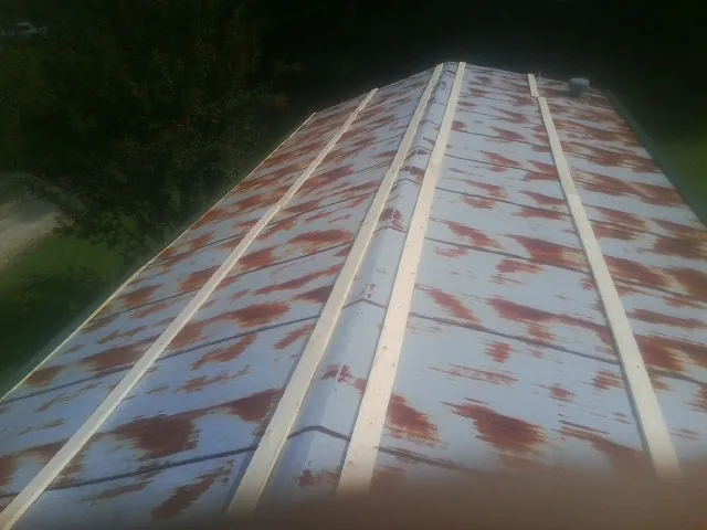 Rusted metal roof panels with new wood purlins before replacement — Storm Damage Roof Repair in Roslyn Heights by Roofing Brothers